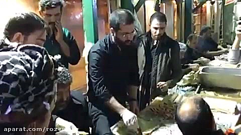 سیب سرخی و حدادیان در حال لقمه گرفتن برای زائران اربعین